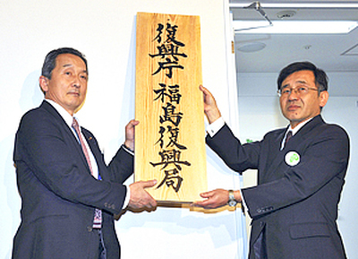 復興庁福島復興局の看板を掛ける吉田泉復興大臣政務官（左）と諸橋省明福島復興局長＝２０１２年２月（肩書は当時）