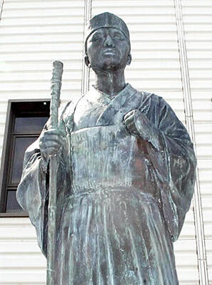 新白河駅正面口前の芭蕉像。黒光りする顔が「早苗にも我色黒き日数哉」の句を連想させなくもない。２００４年、白河ロータリークラブがロータリー１００周年を記念し建立した
