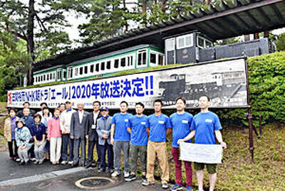 沼尻軽便鉄道のディーゼル機関車と客車の前に、朝ドラ放映記念の横断幕が掲げられた＝７月、猪苗代町「緑の村」