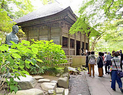 中尊寺の金色堂覆堂（国重要文化財）と芭蕉像。覆堂は、金色堂を覆い保護する建物で、増改築を経て室町時代中期（１６世紀）に現在の形になったとされる。写真の覆堂は１９６３（昭和３８）年まで金色堂を覆っていたが、現在の新覆堂建設に伴い移築された