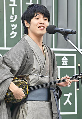 三線と歌を披露する佐久本さん