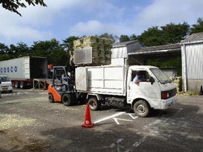 輸入乾草をトラックに積み込む畜産農家＝２０１２年７月