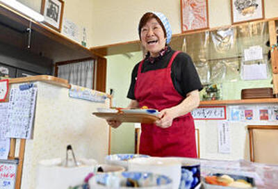 日替わり定食を運ぶ山本さん。明るい笑顔が客の心を引き付ける（吉田義広撮影）