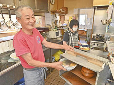 てきぱきと料理を仕上げる雄治さん（手前）。姉の真知子さんとは姉弟ならではのあうんの呼吸だ （吉田義広撮影）