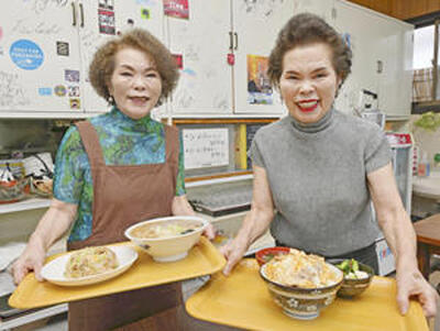 店の「看板娘」の恵子さん（右）と信子さん（左）。双子姉妹の明るく飾らない人柄が客の心を引き付ける（石井裕貴撮影）