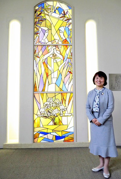 短大の正面玄関に飾られているステンドグラスの前に立つ私。建学の精神そのものだ
