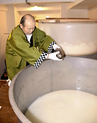 仕込みタンクに沢水を注ぎ入れた佐藤さん