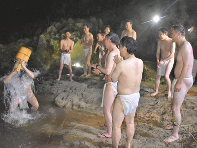 木戸川で水ごりを行って身を清める小塙義団の団員と宇佐神宮司たち＝１０日午後１１時５５分ごろ