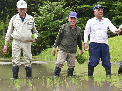 待望の田植えに臨み、笑顔を見せる庄司さん（中央）＝飯舘村長泥地区