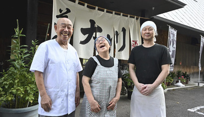 のれんの前で笑顔を見せる（左から）平野旭さん、文子さん、景也さん