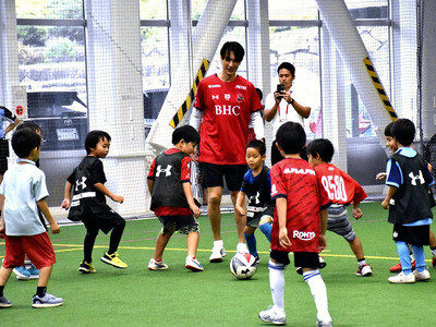 子どもたちにサッカーの楽しさを伝えた高萩さん（中央）
