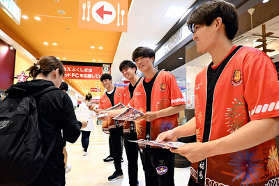 買い物客にチラシを配り、来場を呼びかける松長根選手（右）ら