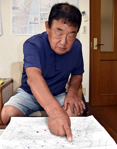 地域の要配慮者の自宅を記した地図を見つめる藤堂さん。「災害時にどう救うか、考えておかなければならない」と話す