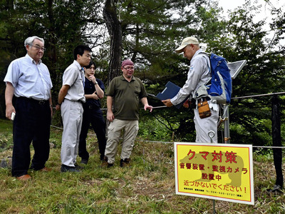 目撃が相次ぐクマへの対策を話し合う関係者。福島市は対策の一環で、荒川周辺に忌避音響装置を取り付けた＝２９日、福島市