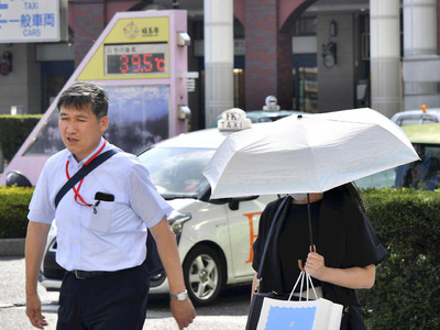 日傘を差して歩く人の姿が見られた福島市。気温計は３９．５度を示していた＝１日午後２時半ごろ、ＪＲ福島駅前