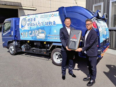 算用子営業本部長からレプリカキーを受ける高崎社長（右）