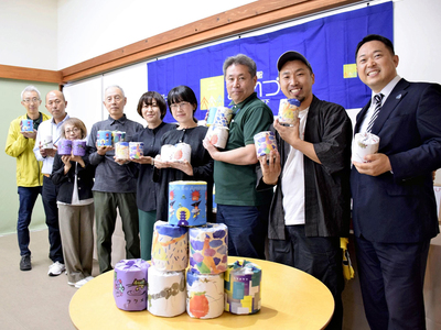 古紙を使ったトイレットペーパーの販売に携わる関係者ら