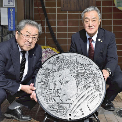 人気漫画「クローズ」の主人公をデザインしたマンホール設置に立ち会う古川町長（左）ら
