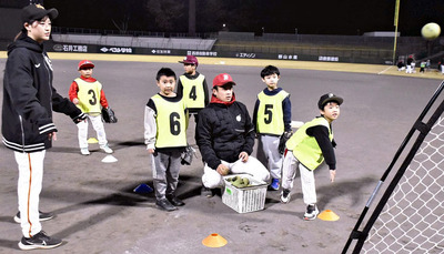 ネットに向かってボールを投げる小学生ら