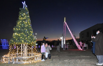 イルミネーションと記念撮影する来場者