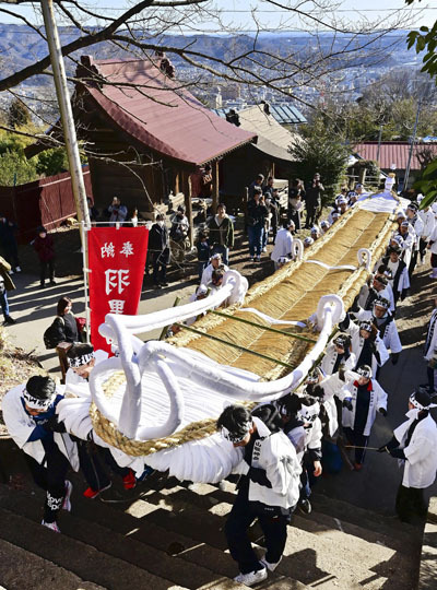 掛け声を響かせ、大わらじを担ぐ人たち。来年２月の「信夫三山暁まいり」では街中を通過するルートが復活する（資料写真）