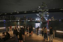 　１７日、ニューヨークのブルックリン橋に衝突したメキシコ海軍の訓練船を見る人たち（ＡＰ＝共同）