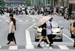 　暖かい空気の影響で気温が上昇した東京・日本橋を歩く人たち＝１８日午後