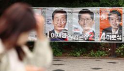 　２３日、ソウル市内に貼られた「共に民主党」候補の李在明氏（左）、「国民の力」候補の金文洙氏（中央）、「改革新党」の李俊錫氏の選挙ポスター（聯合＝共同）