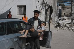 　３０日、イスラエル軍の攻撃後、負傷し病院に運ばれる少年＝パレスチナ自治区ガザ北部ガザ市（ＡＰ＝共同）