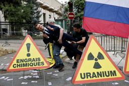 　パリのロシア大使館前にマクロン大統領のろう人形を運び抗議運動を行うグリーンピースの活動家＝２日（ロイター＝共同）