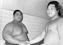 　１９８３年５月、小錦（左）と握手する幕下時代の服部祐児さん＝蔵前国技館