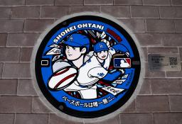 米大リーグ・ドジャースの大谷翔平選手が投打の二刀流で活躍するイラストを描いたマンホールのふた=16日午後、岩手県奥州市のJR水沢江刺駅前