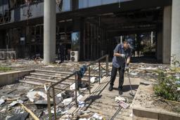 　１６日にイスラエルに攻撃されたイラン国営テレビが入る建物の玄関前で、掃除をする男性＝１９日、テヘラン（ゲッティ＝共同）