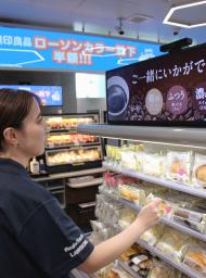 　商品を手に取ると関連のおすすめ商品が表示されるローソン高輪ゲートウェイシティ店のデジタルサイネージ＝２３日午後、東京都港区