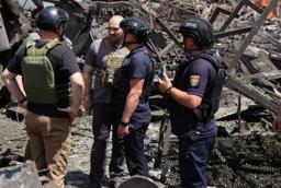 　２４日、ロシア軍の攻撃を受けたウクライナ東部ドニプロペトロウスク州の現場で対応に当たる当局者ら（州政府提供、ゲッティ＝共同）