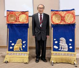 　横綱玉の海の三つぞろいの化粧まわしのうち、太刀持ち（左）と露払いのまわしと写真に納まる「第５１代横綱玉の海を愛する会」の荒島伸好会長＝２８日、名古屋市