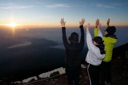 山開きを迎えた富士山の山頂で、御来光に向かって万歳する登山客ら=1日午前4時38分