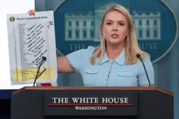 米ホワイトハウスでトランプ大統領がメッセージを書き込んだ各国の金利一覧表を掲げるレビット報道官=6月30日、ワシントン(ロイター=共同)