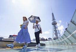 強い日差しの中、名古屋市内を歩く観光客=6月17日