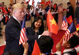 　ハノイでベトナム国旗を手渡されるトランプ米大統領＝２０１９年２月（ロイター＝共同）