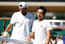 　男子シングルス２回戦で敗れた望月慎太郎（右）＝ウィンブルドン（共同）
