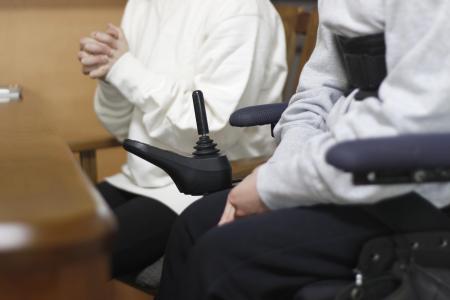 3月、私立高校入試を巡り取材に応じる車いすの生徒(手前)と保護者=香川県内