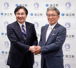 　記者会見後に握手する東北大の冨永悌二学長（左）と福島県浪江町の吉田栄光町長＝１０日午後、同町