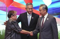 　中国ＡＳＥＡＮ外相会議で、フィリピンのラザロ外相（左）と握手する中国の王毅外相＝１０日、マレーシア・クアラルンプール（ＡＰ＝共同）