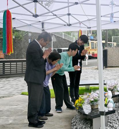 津久井やまゆり園の献花式で、花を手向け手を合わせる入所者と職員=11日午前、相模原市