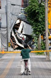 解体工事中の建物が倒壊した現場(奥)=15日午後4時32分、福岡県久留米市