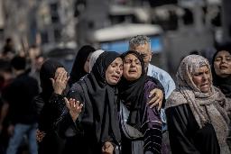6月、ガザ北部ガザ市で、イスラエルの攻撃による親族の死を嘆く人々(ゲッティ=共同)