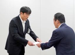 国交省九州運輸局からの改善を指示する文書を受け取る熊本市の井芹和哉交通事業管理者(左)=18日午後、福岡市
