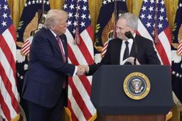 　米政権で暗号資産（仮想通貨）を担当するサックス氏（右）と握手するトランプ大統領＝１８日、ワシントン（ＡＰ＝共同）