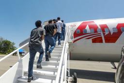 飛行機に乗り出国するベネズエラ人=18日、エルサルバドル南部(同国大統領府提供・ゲッティ=共同)